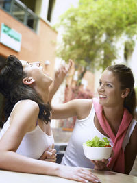 Close-up of smiling young woman eating food