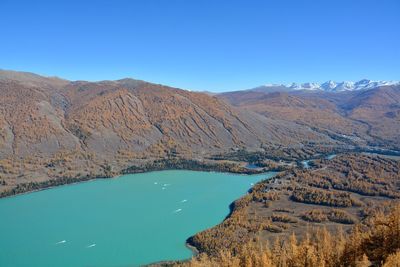 Scenic view of lake and mountains against blue sky