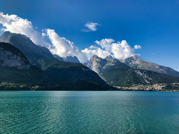 Scenic view of sea by mountains against sky