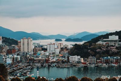 Cityscape by sea against sky