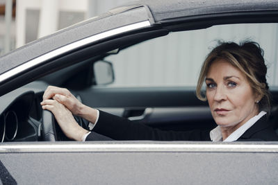 Portrait of confident senior businesswoman in car