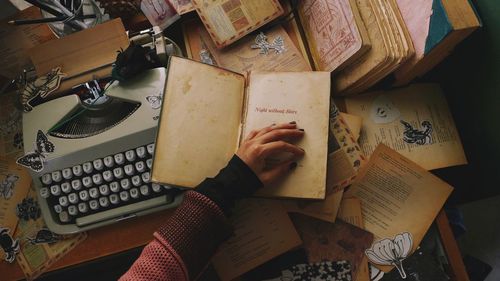 High angle view of hand on open book on table