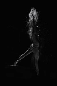 Ballet dancer dancing against black background