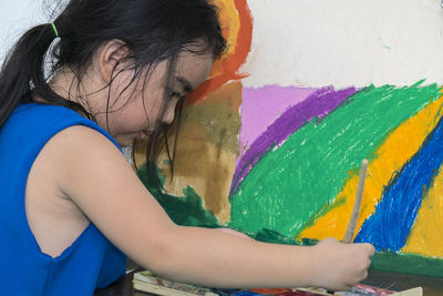 Side view of girl with multi colored wall