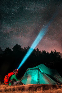 Man standing on field against sky at night