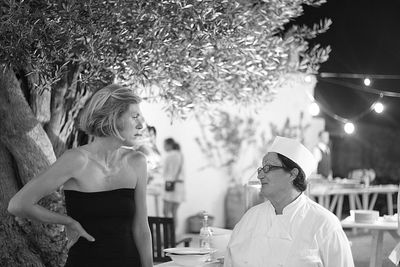 Woman standing and chef standing by tree