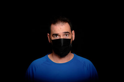 Portrait of young man against black background