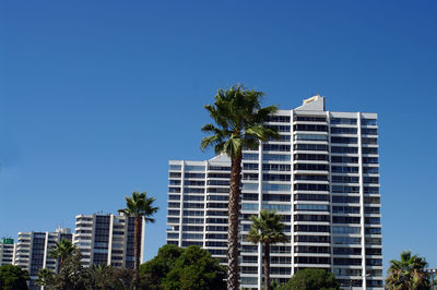 Low angle view of modern buildings against blue sky