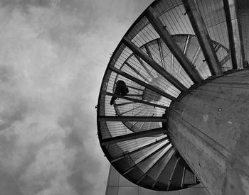 Low angle view of ferris wheel against cloudy sky