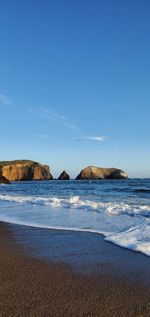 Scenic view of beach against blue sky