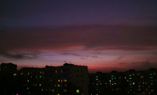 Silhouette buildings against sky at night