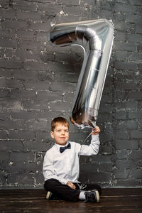 Photo session with a ballon 7 years old. silver ballon with number 7. a boy at a photoset