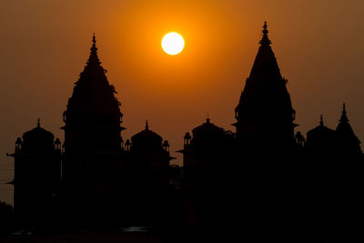 Silhouette of pagoda against sunset sky