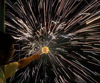 Low angle view of fireworks exploding at night