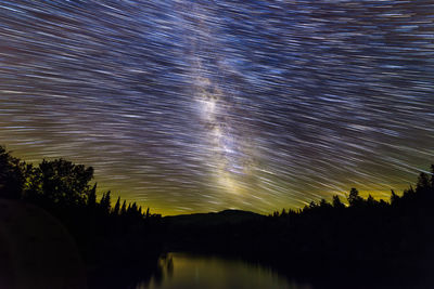 Silhouette trees against sky at night