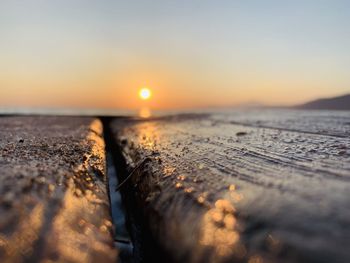 Surface level of sea against sky during sunset