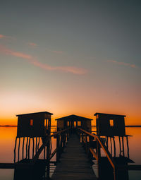 Pier over sea against sky during sunset