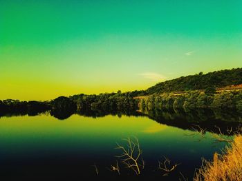 Scenic view of lake against clear sky at sunset