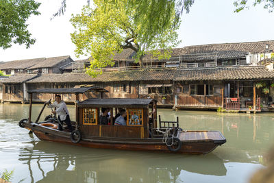 People in boat against river