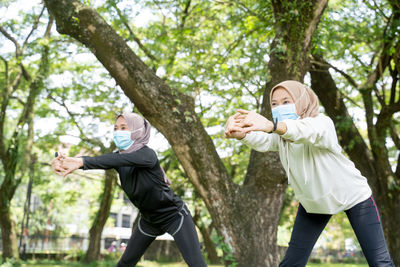 Side view of two people walking in park