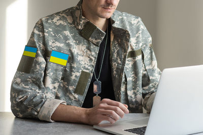 Ukrainian man warrior dressed in a military pixel uniform the yellow-blue flag of ukraine