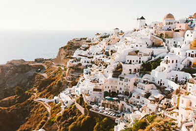 High angle view of townscape by sea against clear sky