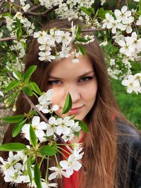 Portrait of beautiful woman by white flowers