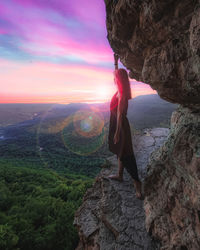 Rear view of woman standing on rock