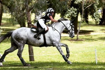 Side view of man riding horse