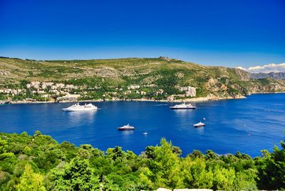 Scenic view of bay against clear blue sky