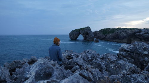 Hiker enjoys scenic view of ocean with unique stone formations