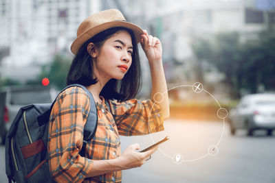 Young woman looking away while using mobile phone