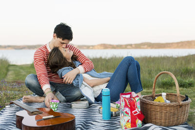 Man kissing girlfriend during picnic