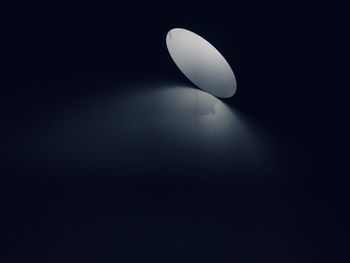 Low angle view of illuminated lamp against black background