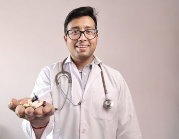 Portrait of smiling young man holding eyeglasses