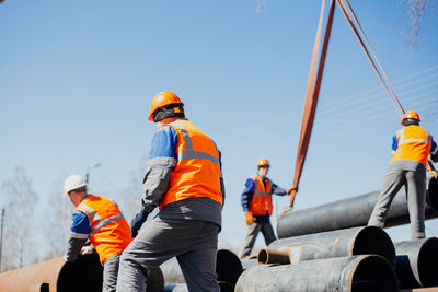 Rear view of manual workers working at construction site