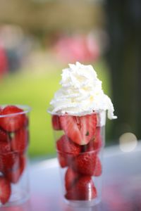 Close-up of whipped cream and strawberries in drinking glass