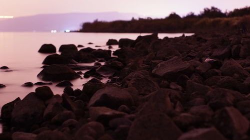 Rocks on shore at sunset
