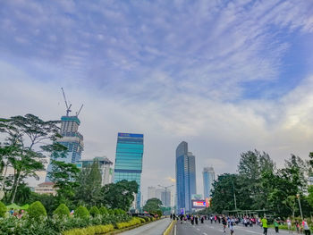 Buildings in city against cloudy sky