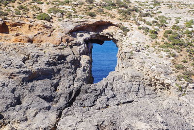 Rock formation in sea against sky