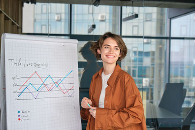 Portrait of young businesswoman standing in office