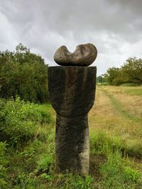 Stone wall on field against sky