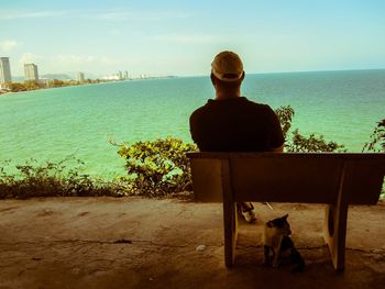 Rear view of dog standing in front of sea