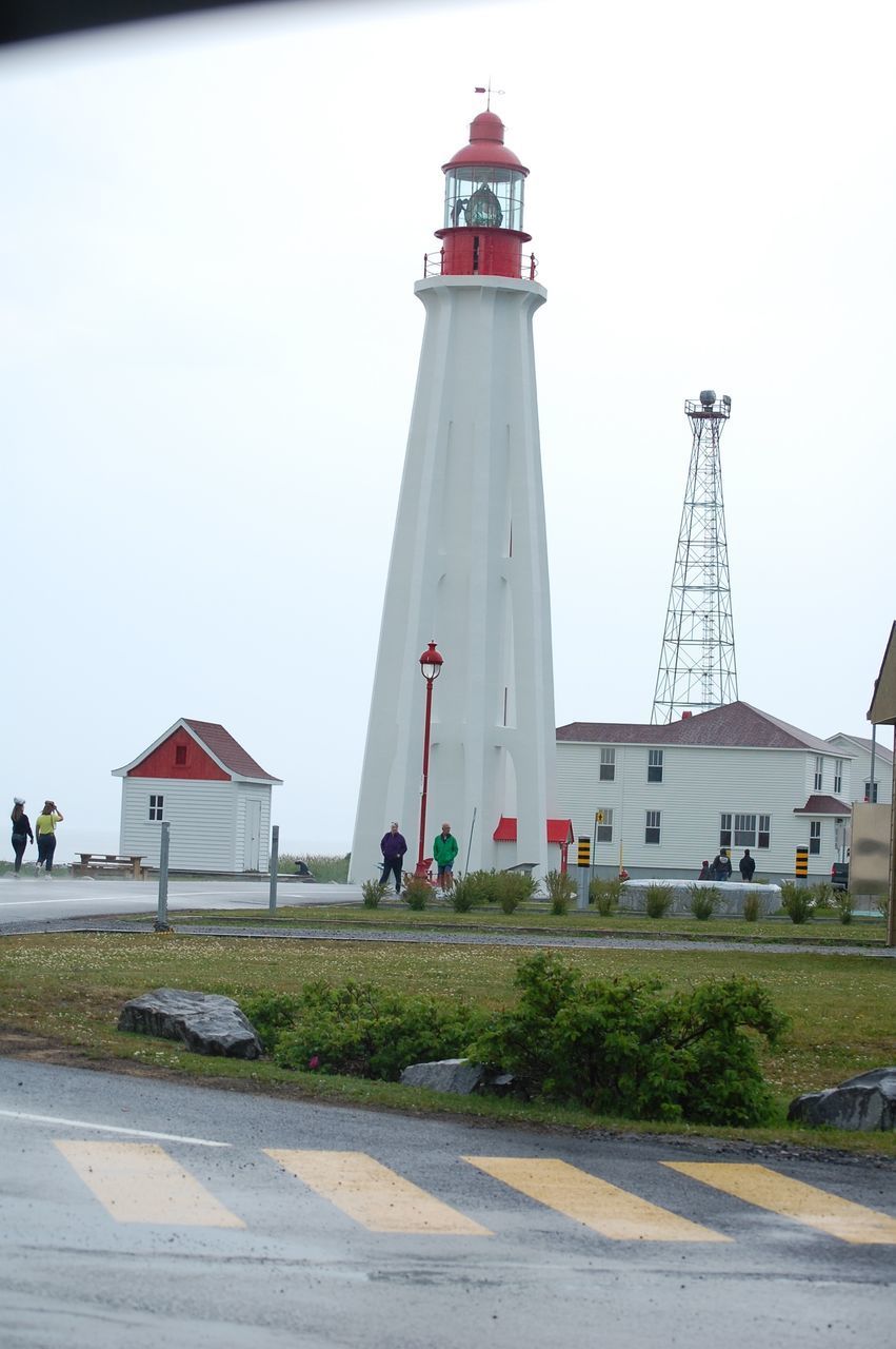 LIGHTHOUSE BY ROAD AGAINST BUILDINGS IN CITY