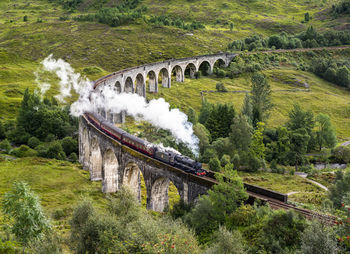 High angle view of train on bridge amidst landscape