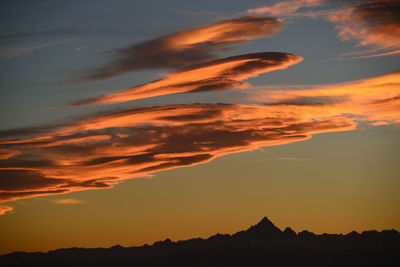 Low angle view of silhouette mountain against dramatic sky