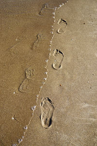 High angle view of footprints on sand at beach
