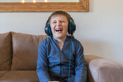 Portrait of happy man sitting on sofa