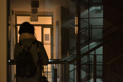 Rear view of woman standing in corridor