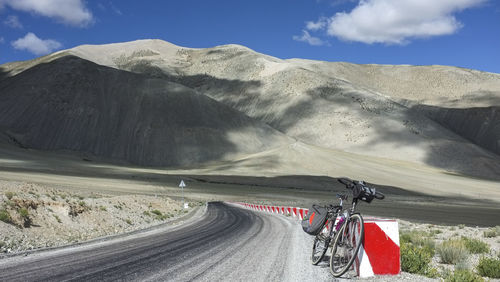 A flat and uninhabited road leads to the foot of the mountain in the distance